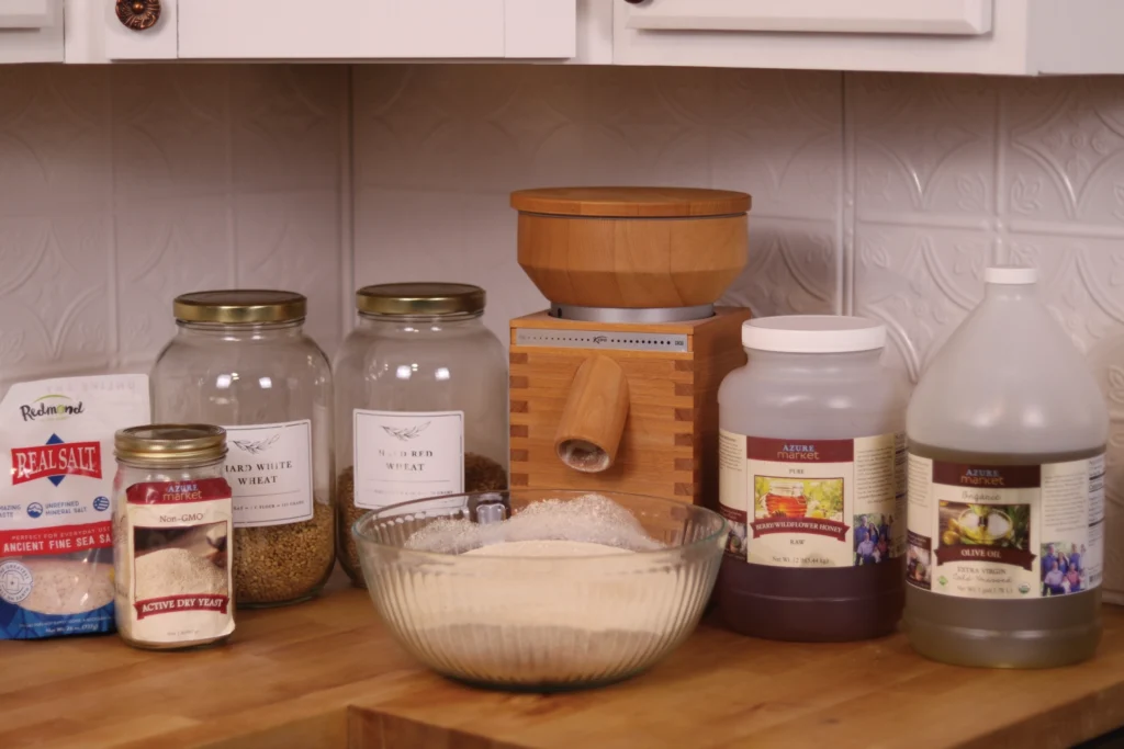 ingredients for dinner rolls on a counter with a grain mill