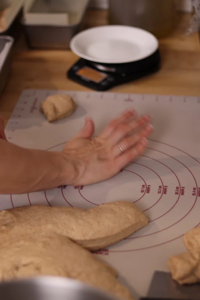 hand pressing a dough ball flat